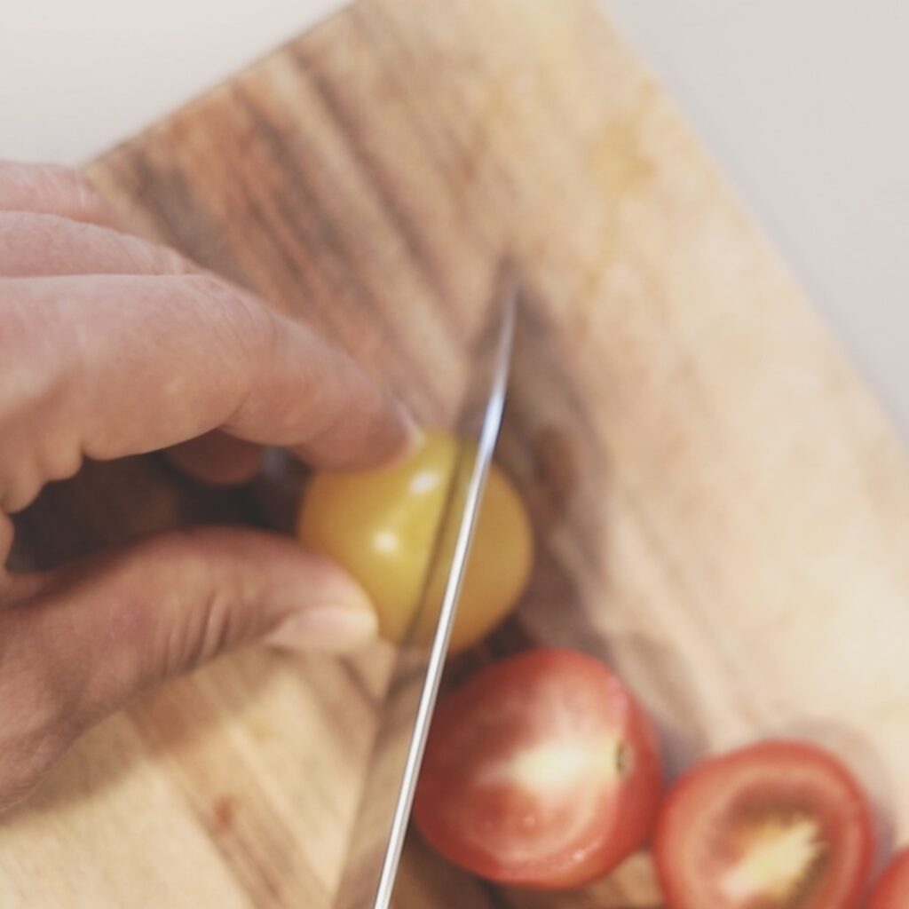 나무도마 위에서 방울토마토를 자르는 모습